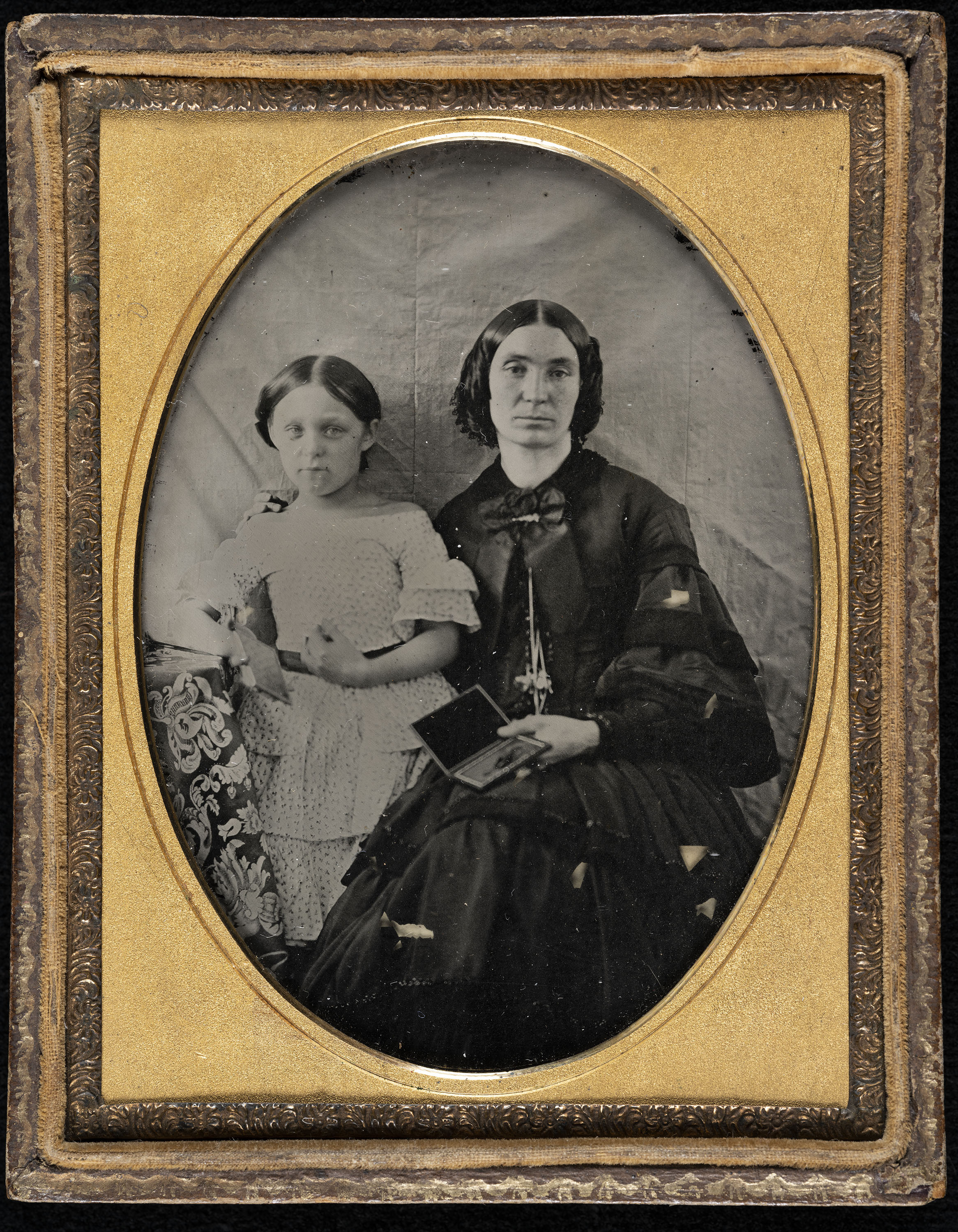 image for: Anònim - Retrat de dona amb ambrotip a la mà i nena - 1860-1870