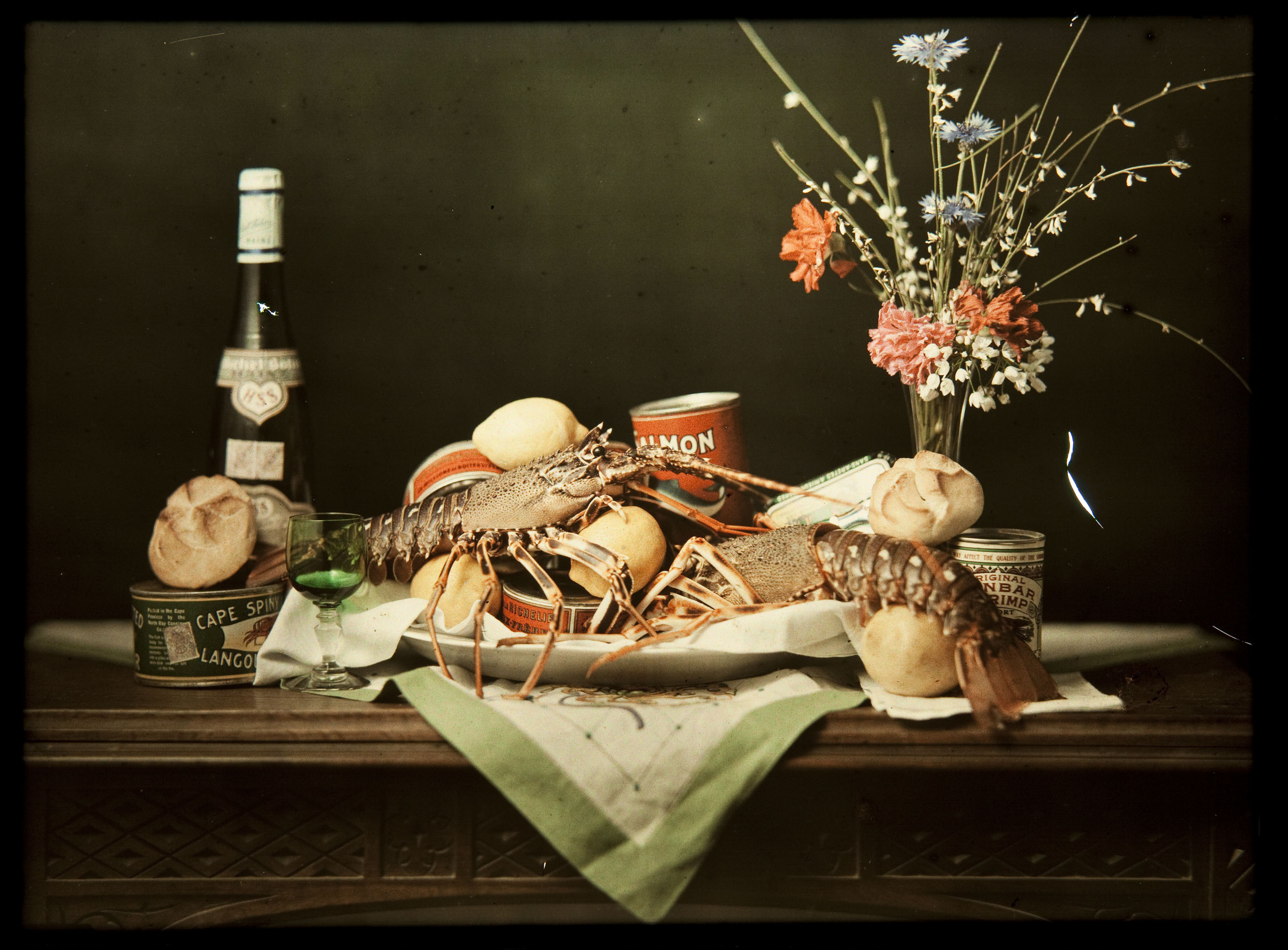 image for: Francesc Carrera Bou - Natura morta amb ampolla de vi, pa, llaunes, llagostes i flors - Cap a 1922-1926