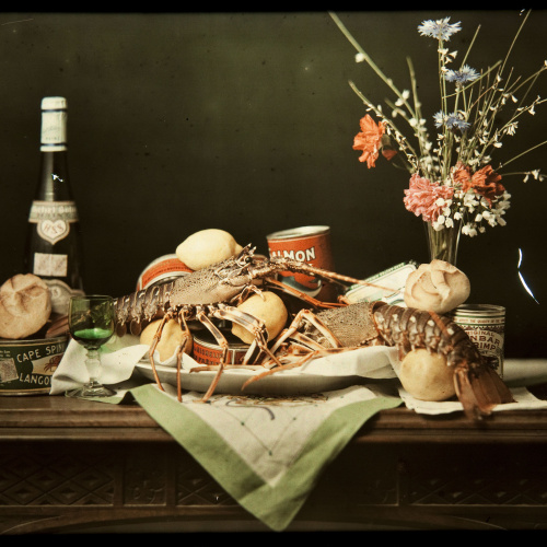 image for: Francesc Carrera Bou - Natura morta amb ampolla de vi, pa, llaunes, llagostes i flors - Cap a 1922-1926